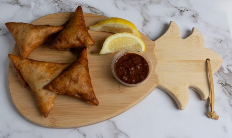Enjoy Ku Mana's Beef Sambusas, savory fried pastries filled with seasoned beef and spices. Photo by @frantzvisuals.