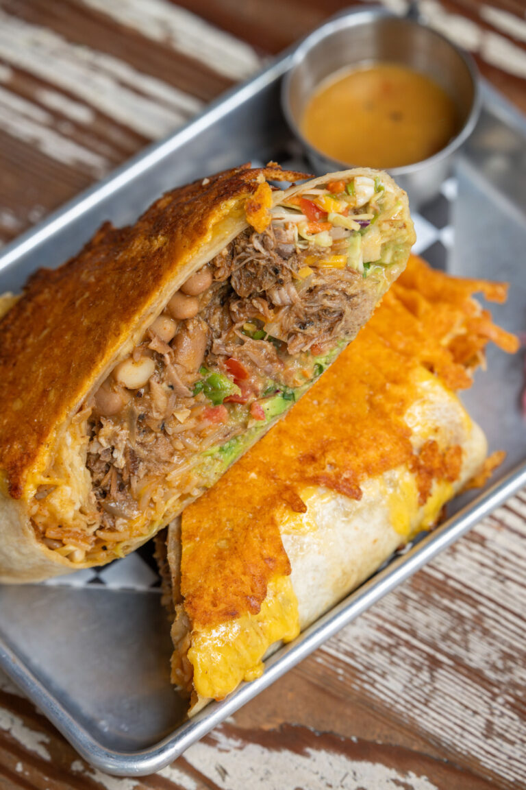 Grilled Cheese Burrito, Carnitas, Toasted Rice, Refried Beans, Mexican Slaw, Guacamole, Pico de Gallo. Photo by Star Chefs.